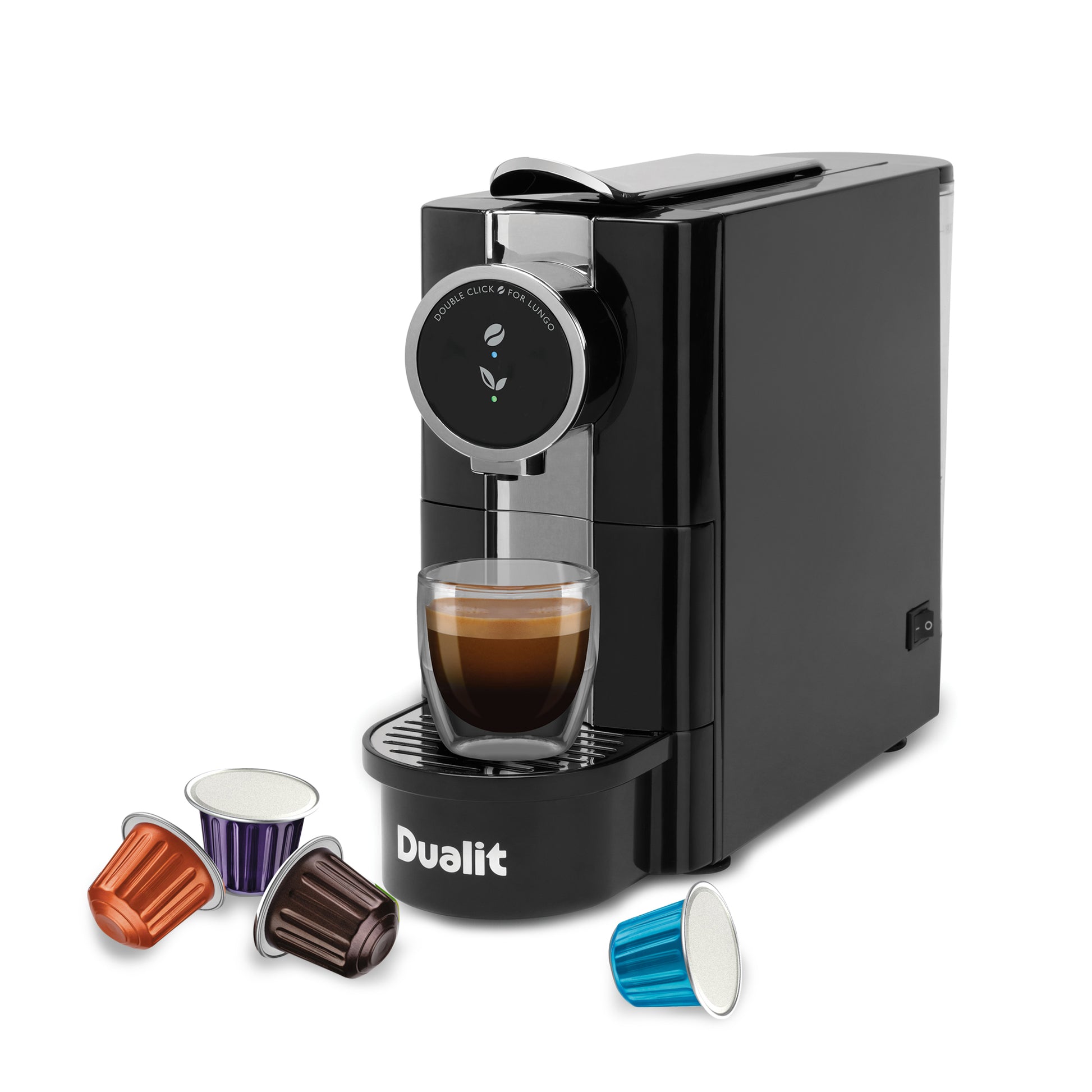 Dualit cafe plus dispensing coffee surrounded by pods from slight right angle