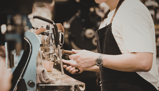 a barista flushing through a coffee machine