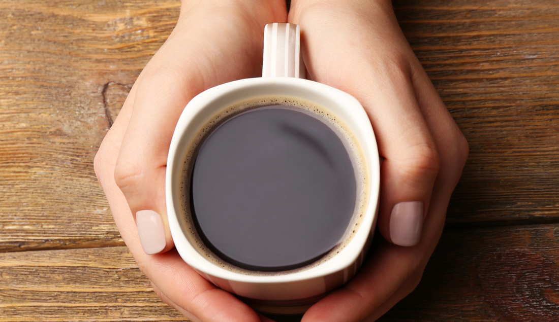 person holding a mug of coffee in their hands