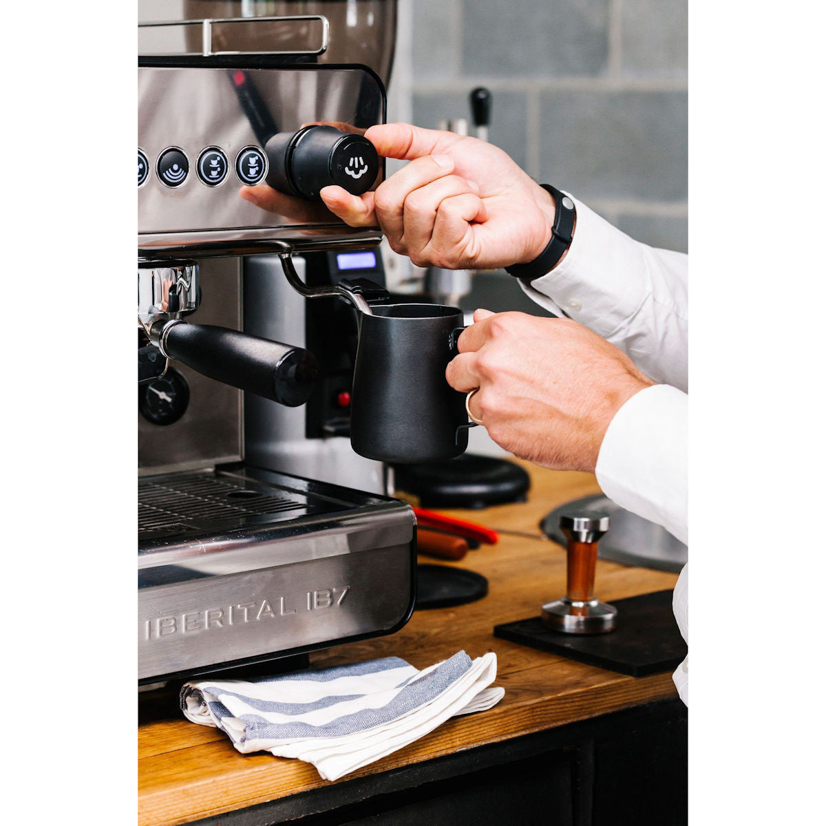 Coffee shop equipment list: barista steaming milk on an Iberital IB7 two group espresso machine