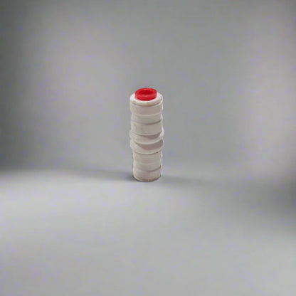White plastic fitting with a red cap on a white surface